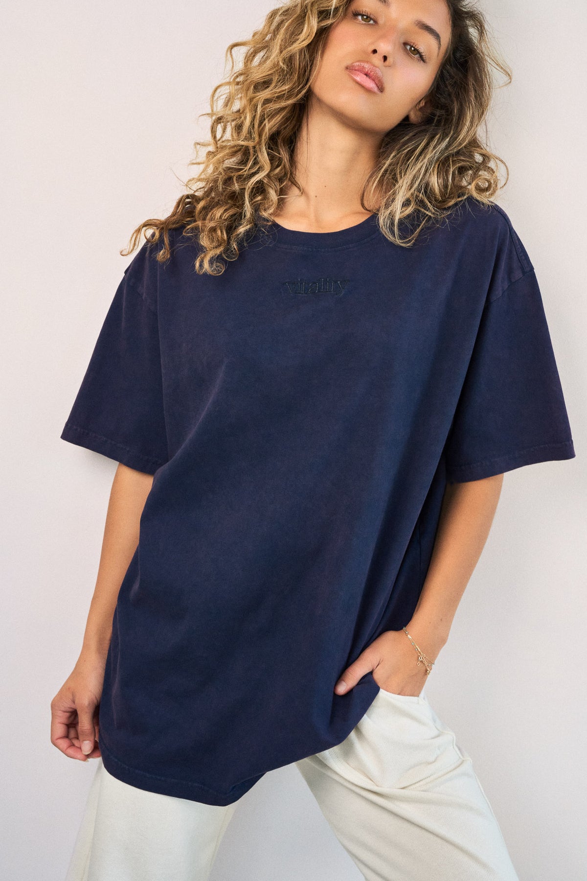 A woman wearing the Vitality Retro Uni Tee - Oxford Washed