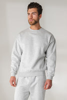 A man wearing the Vitality Uni Cozy Crew - Stone Marl